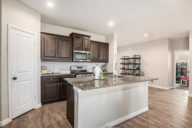 kitchen featuring dark brown cabinets, hardwood / wood-style floors, stainless steel appliances, and sink