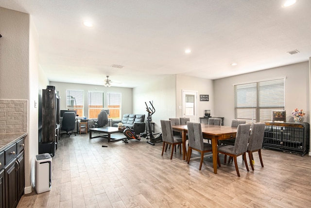 dining area with light wood-type flooring and ceiling fan