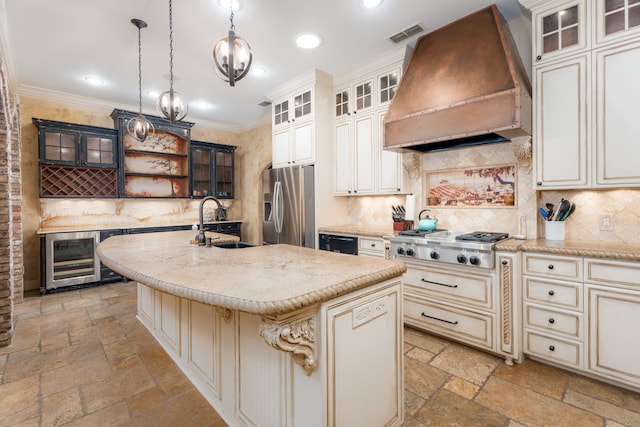 kitchen featuring a kitchen island with sink, custom range hood, stainless steel appliances, wine cooler, and pendant lighting