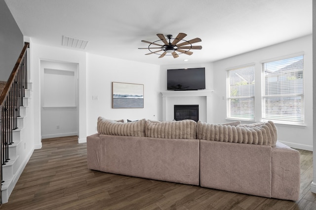 living room with dark wood-type flooring and ceiling fan