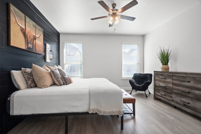 bedroom featuring light hardwood / wood-style flooring, multiple windows, and ceiling fan