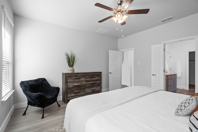 bedroom featuring ceiling fan, ensuite bathroom, and light hardwood / wood-style floors