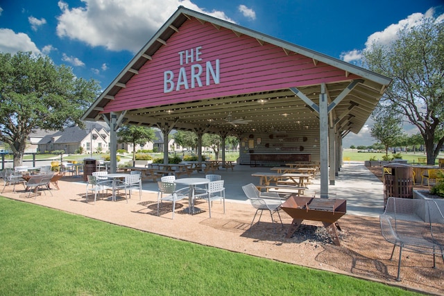 view of property's community featuring a patio and a lawn