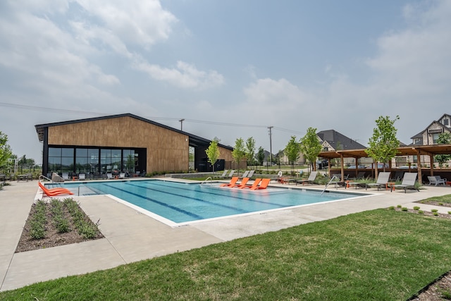 view of pool with a patio and a lawn