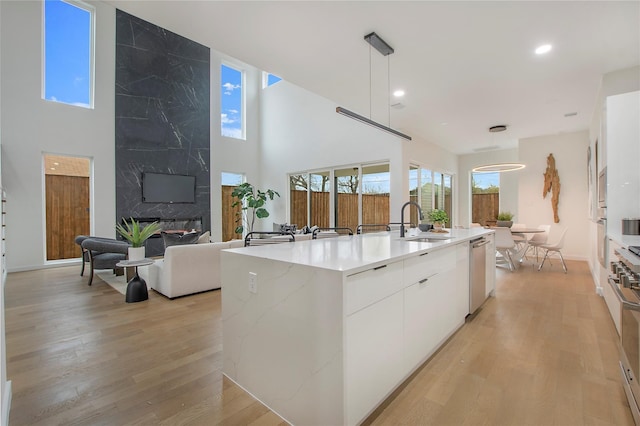 kitchen featuring white cabinetry, a healthy amount of sunlight, stainless steel appliances, and a kitchen island with sink