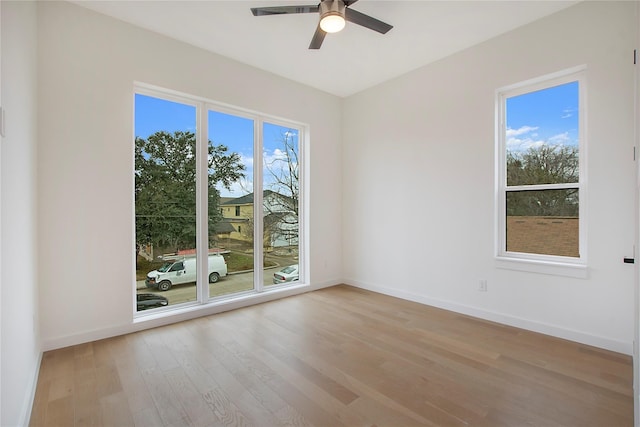 empty room with ceiling fan, light hardwood / wood-style flooring, and plenty of natural light