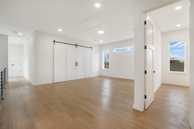 interior space featuring light hardwood / wood-style floors and a barn door