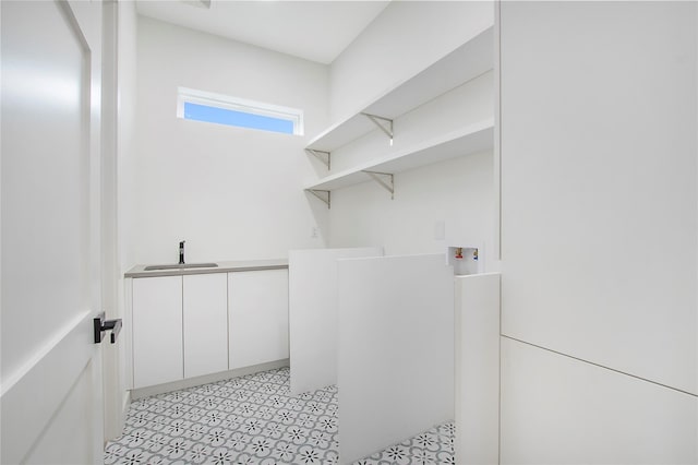 clothes washing area featuring sink, hookup for a washing machine, and cabinets