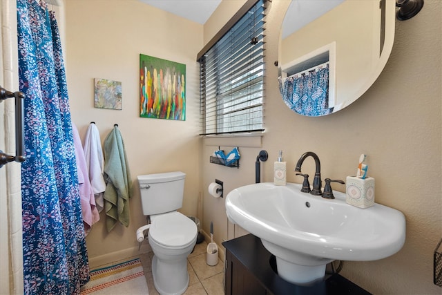 bathroom with sink, toilet, and tile patterned flooring