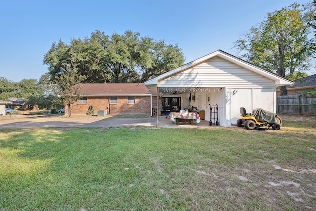 rear view of property with a patio, central AC, and a yard