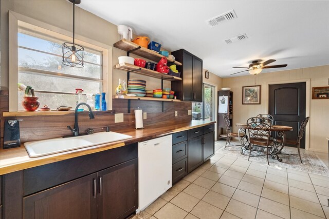 kitchen featuring white dishwasher, sink, light tile patterned flooring, pendant lighting, and ceiling fan