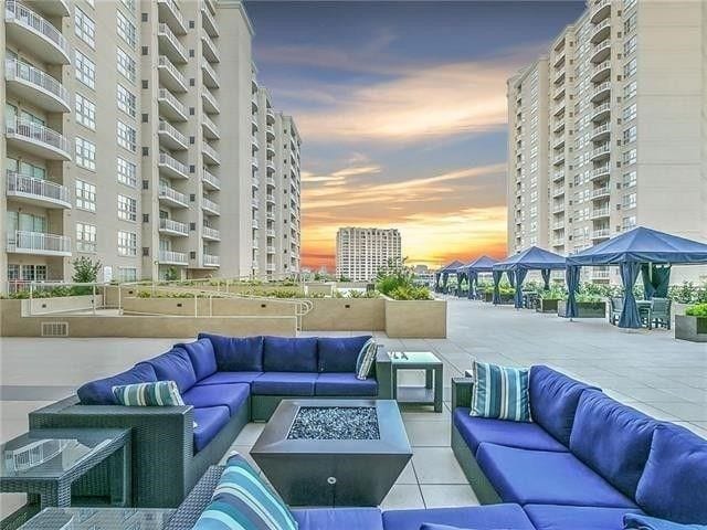 patio terrace at dusk featuring an outdoor living space with a fire pit and a balcony