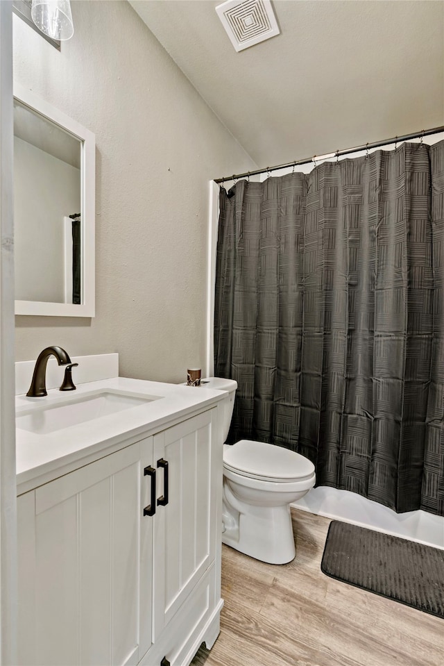 full bathroom featuring vanity, toilet, hardwood / wood-style flooring, and shower / bathtub combination with curtain