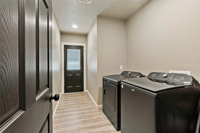 laundry area with light hardwood / wood-style floors and separate washer and dryer