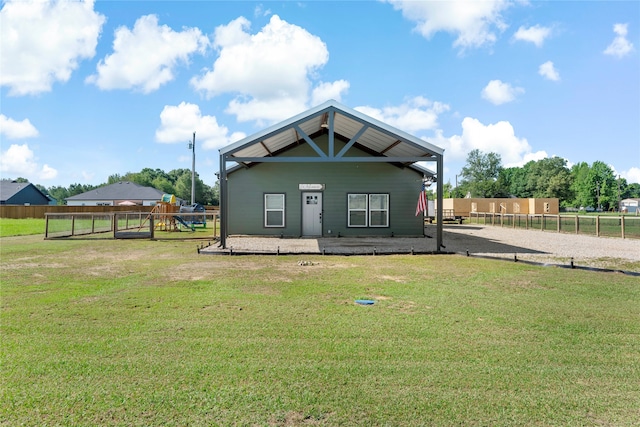 rear view of house featuring a playground and a yard