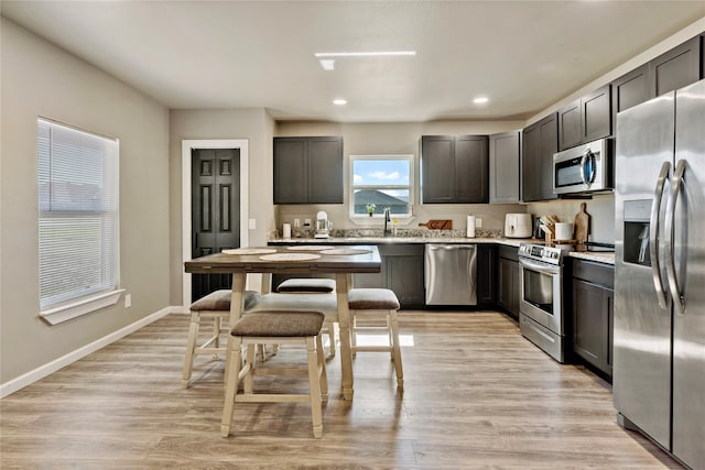 kitchen with light hardwood / wood-style flooring, dark brown cabinetry, and stainless steel appliances