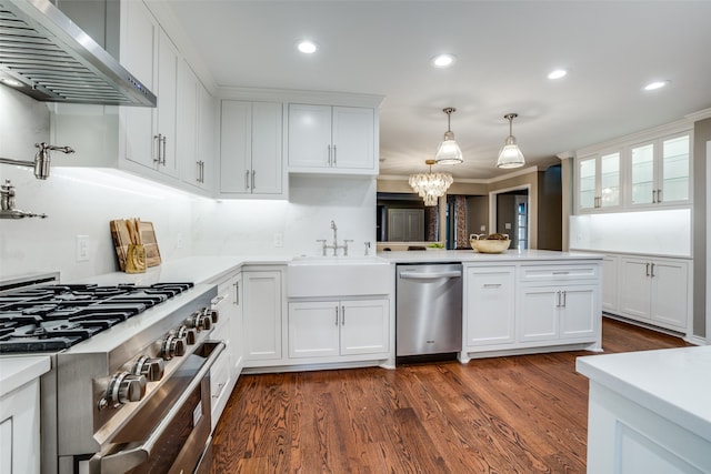 kitchen with dark wood-type flooring, white cabinetry, wall chimney range hood, and stainless steel appliances