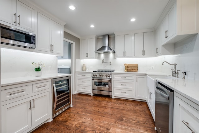 kitchen featuring wine cooler, white cabinets, appliances with stainless steel finishes, dark wood-type flooring, and wall chimney exhaust hood