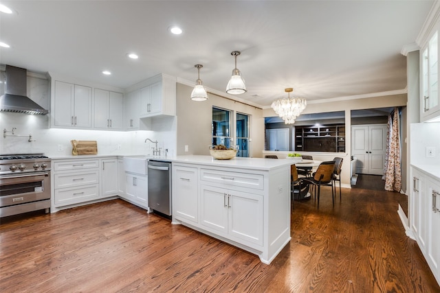 15211 Meandering Way, Dallas, TX 75248 - kitchen featuring wall chimney range hood, a peninsula, a notable chandelier, stainless steel appliances, and recessed lighting
