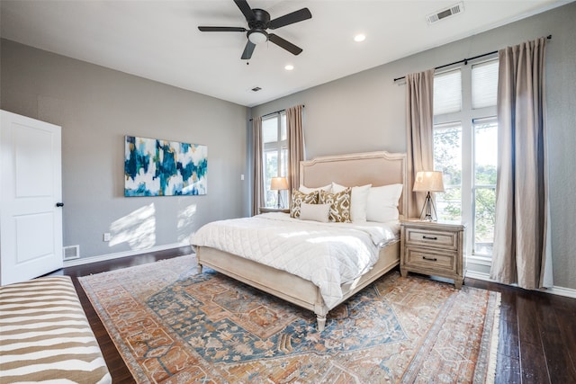 bedroom with dark wood-type flooring, ceiling fan, and multiple windows