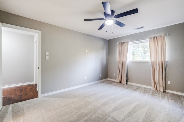 carpeted spare room featuring ceiling fan