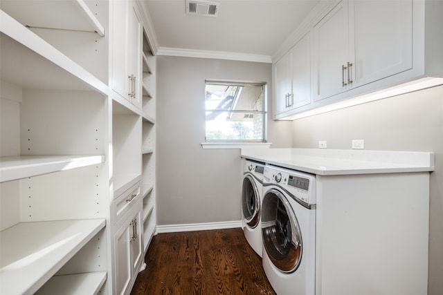 clothes washing area with ornamental molding, dark hardwood / wood-style floors, separate washer and dryer, and cabinets