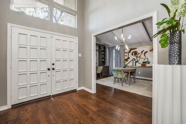 entrance foyer with vaulted ceiling with beams, a notable chandelier, and dark hardwood / wood-style floors