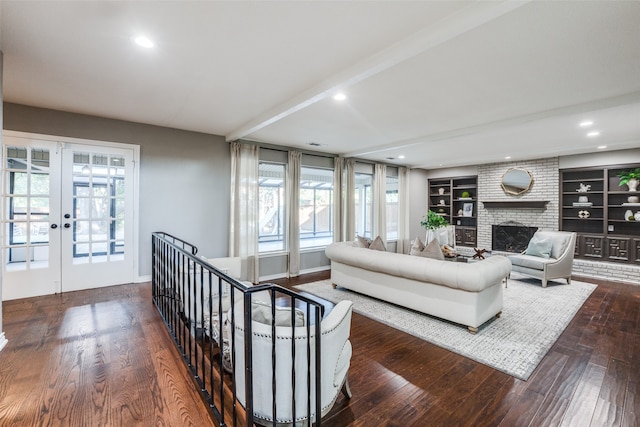 living room featuring french doors, dark hardwood / wood-style flooring, plenty of natural light, and a fireplace