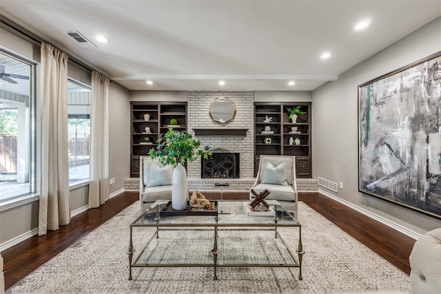 living room featuring dark hardwood / wood-style flooring and a brick fireplace