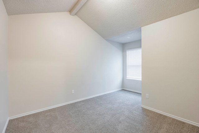 carpeted spare room featuring lofted ceiling with beams and a textured ceiling