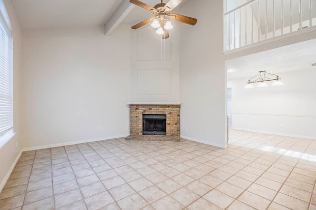 unfurnished living room featuring ceiling fan, beam ceiling, light tile patterned floors, and a fireplace