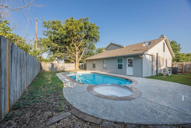 view of swimming pool with an in ground hot tub, a patio area, a lawn, and central air condition unit