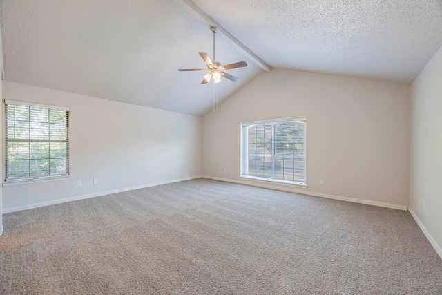 spare room with a wealth of natural light, vaulted ceiling with beams, and carpet floors