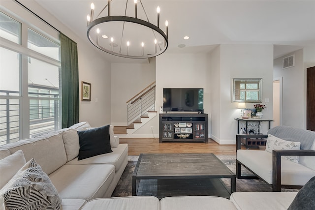 living room featuring an inviting chandelier, hardwood / wood-style flooring, and a high ceiling