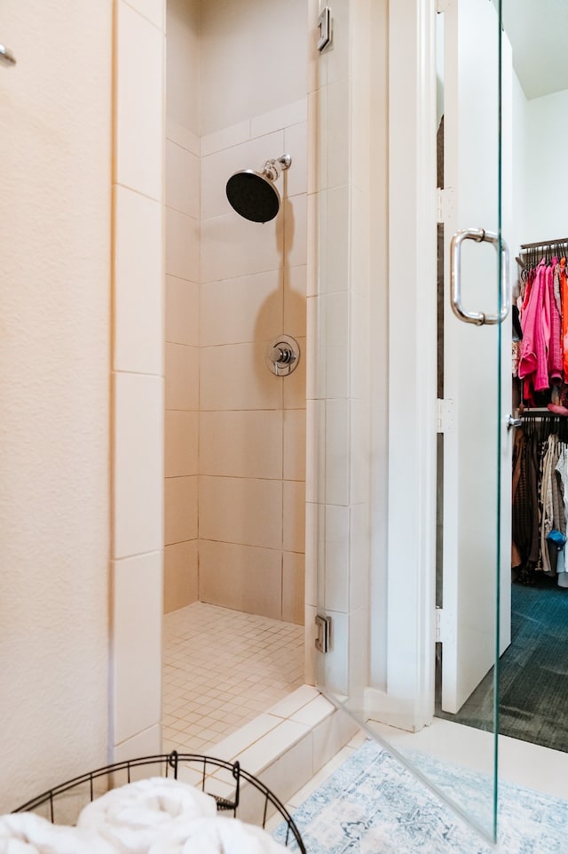 bathroom with a shower with door and tile patterned flooring