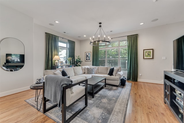 living room featuring light hardwood / wood-style flooring and an inviting chandelier