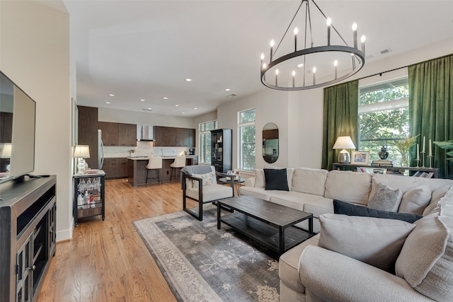 living room featuring a chandelier and light wood-type flooring