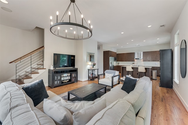 living room featuring light hardwood / wood-style flooring and a notable chandelier