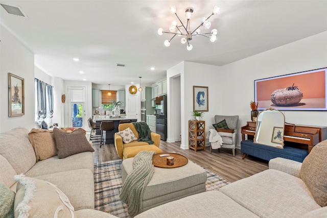 living room with hardwood / wood-style flooring and an inviting chandelier