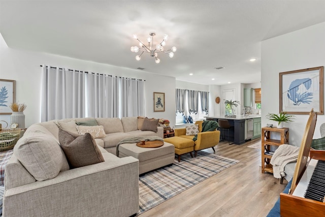 living room featuring a notable chandelier and light hardwood / wood-style flooring