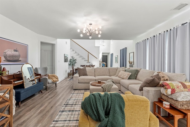 living room with wood-type flooring and an inviting chandelier