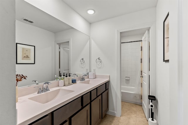 bathroom with vanity, tiled shower / bath combo, and tile patterned flooring