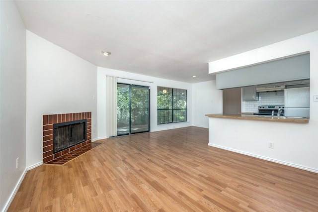 unfurnished living room featuring a fireplace and light hardwood / wood-style floors