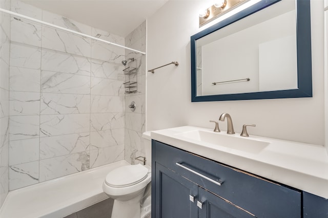 bathroom featuring vanity, toilet, and tiled shower