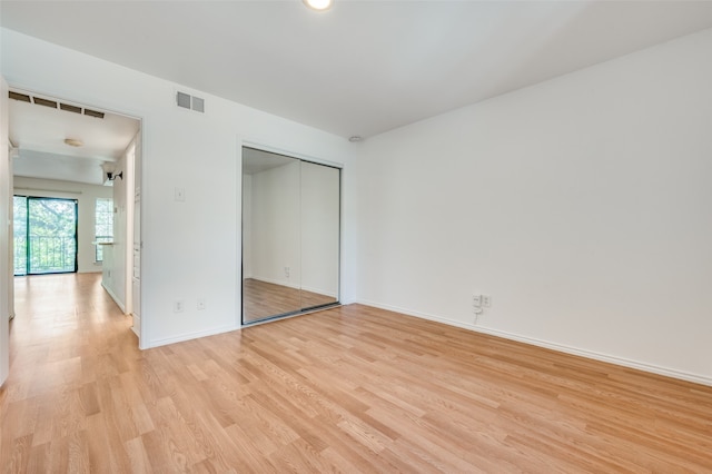 unfurnished bedroom featuring light hardwood / wood-style flooring and a closet