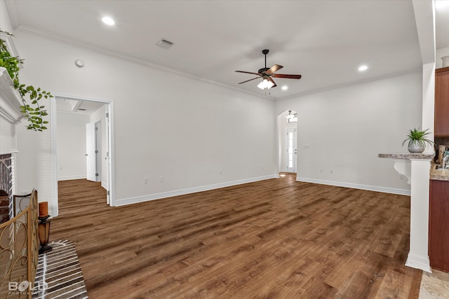 unfurnished living room with crown molding, dark hardwood / wood-style floors, a fireplace, and ceiling fan