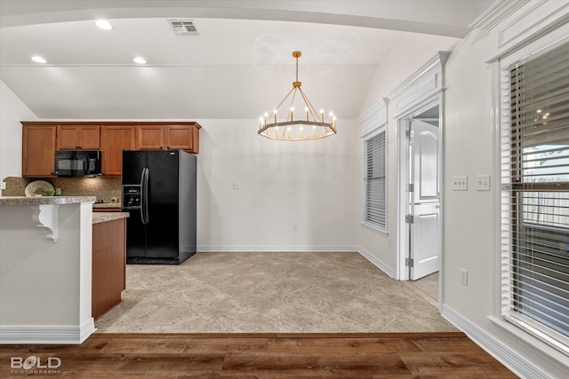 kitchen featuring an inviting chandelier, black appliances, vaulted ceiling, and light wood-type flooring