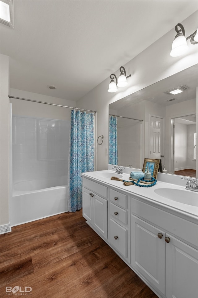 bathroom with vanity, wood-type flooring, and shower / bath combo with shower curtain