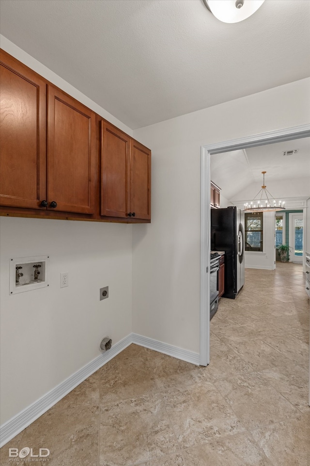 laundry room with hookup for an electric dryer, washer hookup, cabinets, and a chandelier