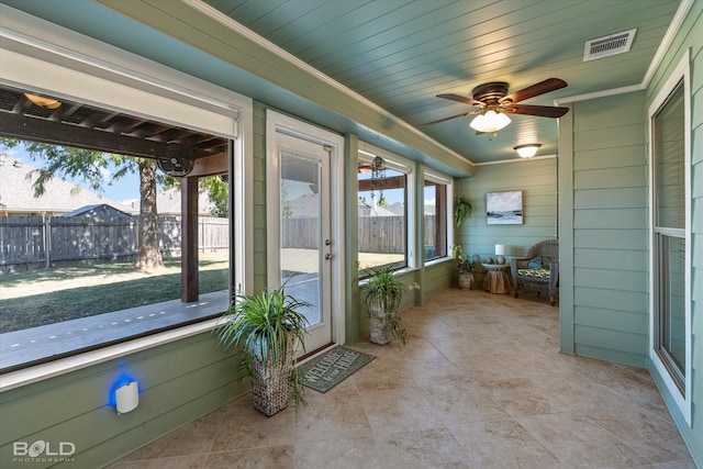 unfurnished sunroom with wood ceiling and ceiling fan